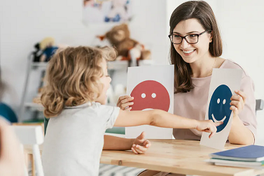 imagen de un niño pequeño reconociendo tarjetas de emociones